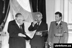 Голова уряду Української Народної Республіки в екзилі Іван Самійленко в Маріїнському палаці передає президентові України Леоніду Кравчуку державну печатку та альбом із фотографіями діячів УНР. Київ, 22 серпня 1992 року