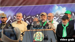 تصویری بدون تاریخ از رائد سعد (پشت میکروفن) در کنار اسماعیل هنیه