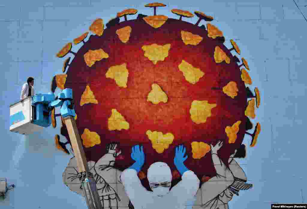 Казахський художник працює над великим муралом у Алмати, присвяченому медикам, які борються із COVID-19 (Reuters/Pavel Mikheyev)