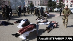 Українські військовослужбовці та рятувальники допомагають пораненим внаслідок ракетного удару російських військових по залізничному вокзалу в Краматорську, 8 квітня 2022 року