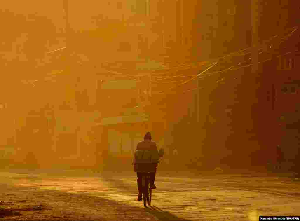 Рано вранці чоловік їде на велосипеді у столиці Непалу Катманду, де оголошений карантин через коронавіру. (epa-EFE / Narendra Shrestha)