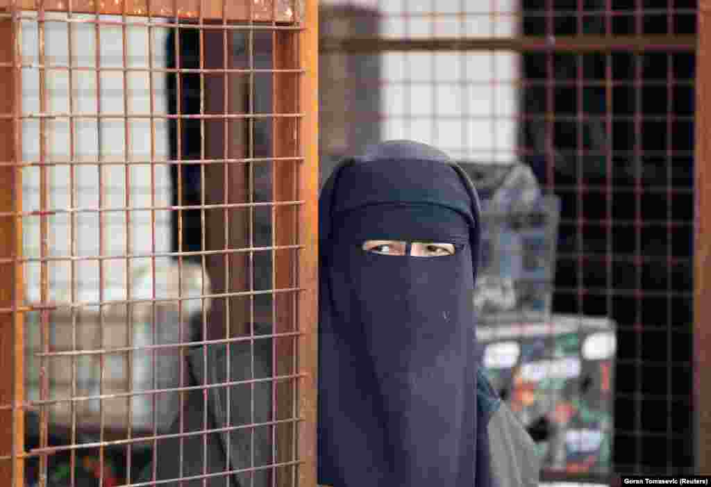 A woman looks out at the al-Hol camp.