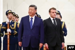 Голова Китаю Сі Цзіньпін стоїть поруч із президентом Франції Емманюелем Макроном під час церемонії привітання у Домі народних зборів у Пекіні 4 грудня 2025 року