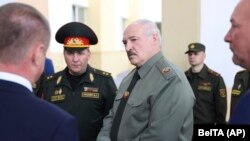 Belarusian President Alyaksandr Lukashenka (center) attends a meeting on territorial defense issues in the town of Shklov in June with Defense Minister Viktar Khrenin (left).