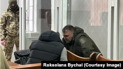 Дмитро Козюра, підозрюваний у державній зраді, розмовляє із адвокатом, під час судового засідання, де йому обирали запобіжний захід на час досудового розслідування