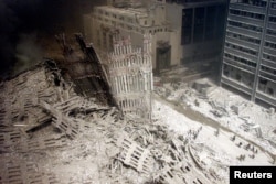Un grup de pompieri se plimbă printre dărâmături în apropierea bazei unuia din turnurile gemene, distruse la data de 11 septembrie 2001. În cel mai grav atac terorist petrecut vreodată în Statele Unite, două avioane deturnate s-au izbit de cele două turnuri ale complexului World Trade Center din New York. Un al treilea avion a lovit Pentagonul, iar un al patrulea s-a prăbușit pe un câmp din statul american Pennsylvania.