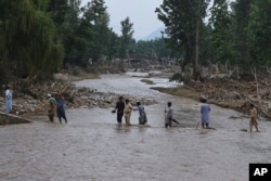 د بونېر په بیشوڼۍ کلي کې یوشمېر کسان د سېلاب پر مهال له خوړه تېرېږي - د اګست ۱۷مې انځور.