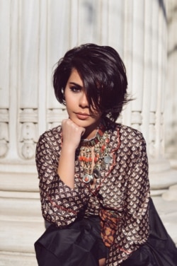 Safia wears a traditional handmade orange colored Afghan choker-style necklace. Choker-style necklaces are staple Afghan jewelry pieces, mostly made of metal, silver, or sometimes gold plated silver.