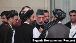 FILE: Former Afghan President Hamid Karzai (2nd R) and cheif Taliban negotiator Mullah Abdul Ghani Baradar (3rd R) talk in Moscow.