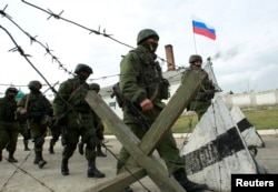 Военные, предположительно российские, маршируют близ украинской воинской части в селе Перевальное близ Симферополя. 4 марта 2014 года.