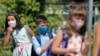 Alegra Bajrami (left), wearing a face mask to protect against the coronavirus, enters a schoolyard on the first day of the new academic year in Kosovo&#39;s capital, Pristina. Kosovar schools reopened on September 14 for the first time since March when the COVID-19 crisis began.