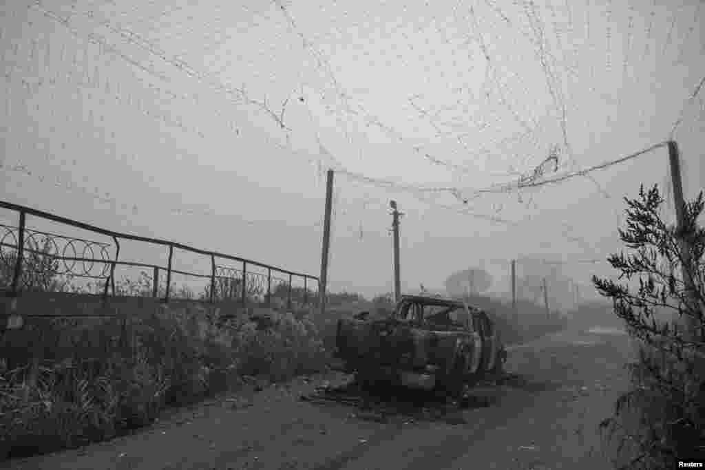 Izgorjelo vozilo ostalo je na sredini ulice koja je bila prekrivena antidron mrežom, blizu gradića Huljapol u Zaporoškoj oblasti. Mreža je oštećena ruskim napadima. 14. novembar 2025.