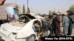 Security officials inspect the scene of a blast in Lashkar Gah, the provincial capital of Helmand, that killed Radio Free Afghanistan journalist Mohammad Ilyas Dayee on November 12, 2020.