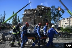 Рятувальник ДСНС несуть тіло людини, загиблої внаслідок російського ракетного удару по житловому будинку. Київ, 28 серпня 2025 року