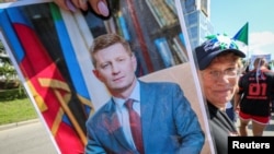 A protester holds up a picture of Sergei Furgal, the former governor, at a march in Khabarovsk on September 5.