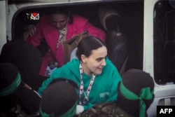 Emily Damari și Romi Gonen coboară dintr-un vehicul în timpul procesului de predare către Comitetul Internațional al Crucii Roșii în Piața Saraya din orașul Gaza, 19 ianuarie 2025. Captură preluată dintr-un videoclip difuzat de Biroul de presă al Hamas.