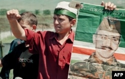 Чеченський хлопець із портретом Джохара Дудаєва вимагає виведення російських військ із Сірноводська, червень 1996 року