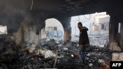 Газадагы Израил армиясынын аба соккусунан жабыркаган имараттын ичинде турган палестин жигит. 17-декабрь, 2024-жыл. 