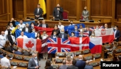 Депутати у Верховній Раді тримають державні прапори країн-партнерів України, щоб висловити свою вдячність за політичну підтримку та військову допомогу Українській державі. Київ, 1 лютого 2022 року