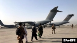 تعدادی از افغانها که در برنامه تخلیه از میدان هوایی کابل توسط طیاره های نظامی انتقال داده شدند.