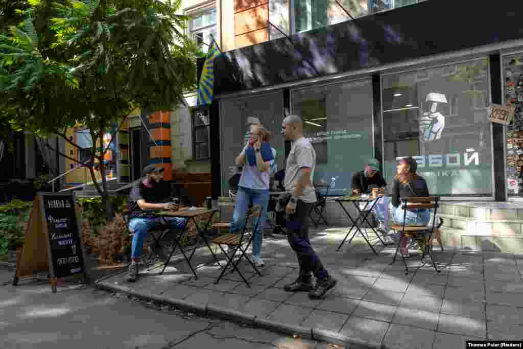 Žena zatvara uši dok ruski dron leti iznad naselja u kojem se nalaze prodavnice, u gradu na liniji fronta, Kramatorsk. 10. septembar 2025.