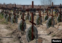Graves of unidentified people killed by Russian soldiers during the occupation of Bucha, Ukraine, are seen at the town's cemetery on March 30.