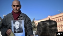 A man holds his father's portrait near a memorial to the victims of Soviet-era political repressions on Lubyanka Square in Moscow on October 29.
