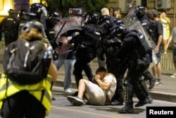 Сербські поліцейські затримують демонстранта під час сутичок між прихильниками правлячої партії та антиурядовими протестувальниками в Белграді, Сербія, 13 серпня 2025 року