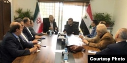 عباس اکبری (وسط، نفر نزدیک به پرچم سوریه) در شورای اتاق مشترک بازرگانی سوریه و ایران در دمشق، اردیبهشت ۱۴۰۱