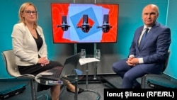 Interim Romanian President Ilie Bolojan (right) at the Bucharest office of RFE/RL on May 12 for an interview ahead of this weekend's runoff election between ultranationalist politician George Simion and pro-Western reformist Nicusor Dan.