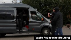 Polițiștii care au reținut un jurnalist care era în misiune sunt fotografiați de un fotograf Reuters cu puțin timp înainte de reținerea sa