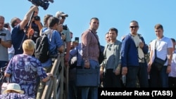 President Volodymyr Zelensky (3rd from right) talks to journalists and local residents at a partially destroyed bridge near Stanytsya Luhanska on July 7.