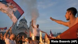 Поддржувачите на опозицијата слават по парламентарните избори пред Српската православна црква Христово воскресение во Подгорица, Црна Гора, понеделник, 31 август 2020 година.