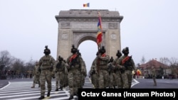 Soldați români se pregătesc pentru parada de 1 Decembrie. De 35 de ani, Unirea de la 1 Decembrie 1918 a devenit Ziua Națională. Înainte de ocupația sovietică, se celebra pe 10 Mai, Ziua Independenței. A urmat 23 august, zi a cărei semnificație a fost confiscată de comuniști.
