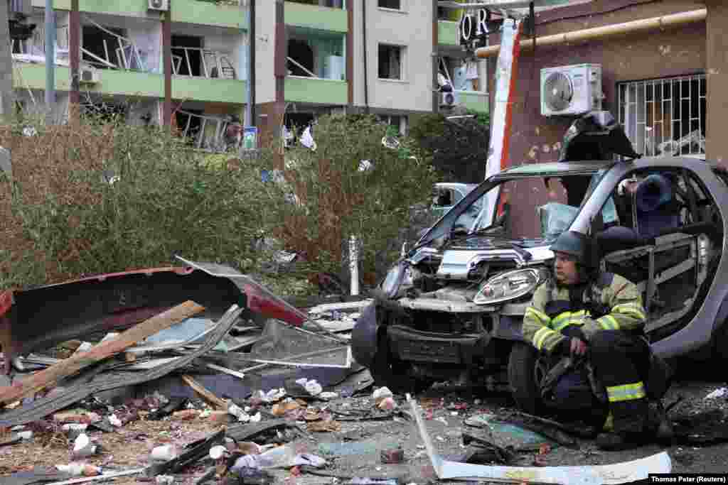 Рятувальник відпочиває під час ліквідації наслідків російської атаки на передмістя Києва