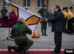 Ватажок угруповання «ЛНР» Ігор Плотницкий під час церемонії вручення «бойового прапора» одному зі збройних підрозділів цієї організації, яку в Україні визнано терористичною. Недале від нього стоять кілька священиків