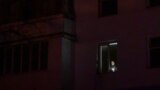 Un bărbat ține o lanternă la fereastra apartamentului său, în timpul deconectării programate a curentului electric la Varnita, în Zona de Securitate, 17 ianuarie 2025.