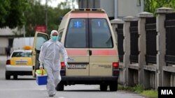 Илустрација - Медицинско лице транспортира материјал за тестирање на коронавирус во лабораторијата во МАНУ.