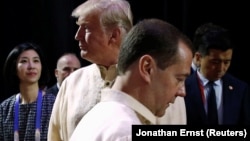 Прэзідэнт ЗША Дональд Трамп і прэм'ер-міністр Расеі Дзьмітрый Мядзьведзеў (зьлева) на ўрачыстай вячэры на саміце Асацыяцыі дзяржаў Паўднёва-Усходняй Азіі ў Маніле, 12 лістапада 2017 году.