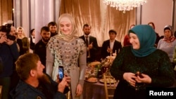 Çeçenistan lideri Ramzan Kadırov və xanımı Medni Qroznıda qızları Ayşat Kadırovanın (mərkəzdə) "Firdaws" moda evinin geyim nümayişində.