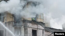 Un salvator lucrează pe o clădire avariată din Kiev, după un atac rusesc cu rachete. 21 martie 2024. REUTERS