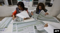 د بغداد په المهندسین ناحیه کې د انتخاباتو د کمیسیون دوه ښځینه کارکوونکې د رایو د شمېرنې پرمهال