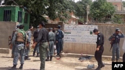 FILE: Policemen stand at the site of a suicide bombing in front of the provincial council building in the city of Puli Khumri, capital of northern Baghlan Province.