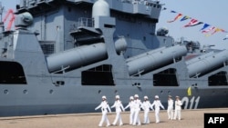 شماری از عساکر چینی در حال رسم گذشت در برابر یک کشتی نظامی روسیه(آرشیف)