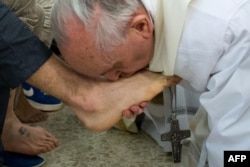 Papa Francisc sărută picioarele unui deținut după ce le-a spălat în timpul unei slujbe la biserica închisorii pentru tineri Casal del Marmo de la periferia Romei, martie 2013.