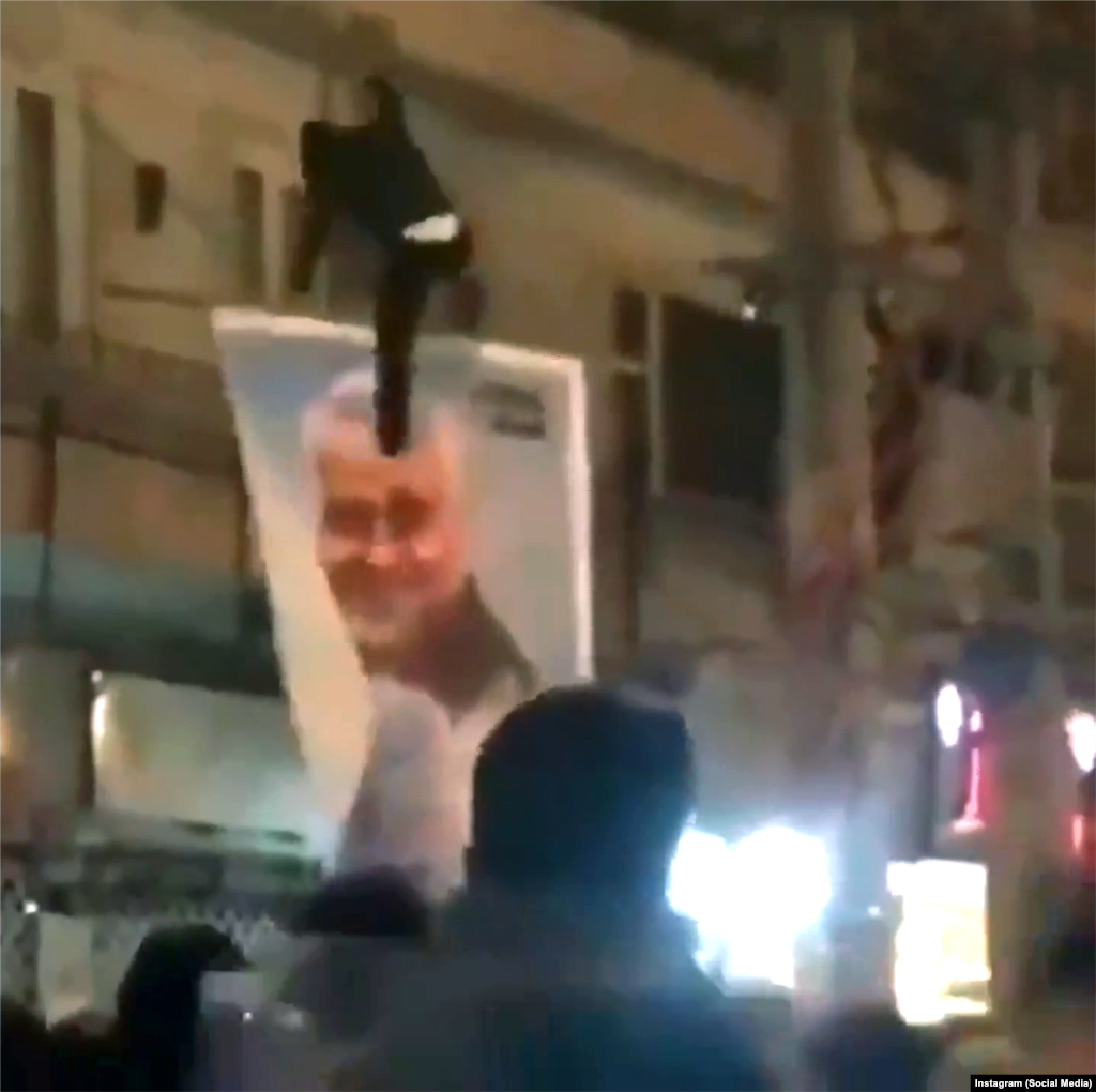 Un protestatar lovește cu piciorul portretul generalului ucis Qasem Soleimani în Teheran, pe 12 ianuarie.