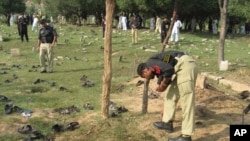 A police officers collects evidence at the site of a suicide bombing in Lower Dir in September 2011. (file photo)