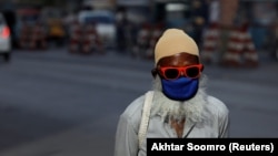 A man wearing a protective face mask walks along a road, as the outbreak of the coronavirus disease (COVID-19) continues in Karachi on June 2.