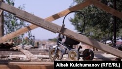 Ак-Бешим айылы. Каргаша баскан үйдөгү балдар арабасы 