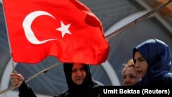 Туркиянинг байроғини кўтариб турган аёл. Расм иллюстрация учун ишлатилди. 